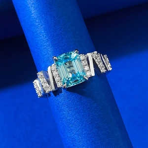 Emerald-cut light blue gemstone ring with geometric silver band and sparkling side diamonds