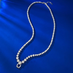 Collier tennis élégant en argent avec pendentif diamant sur fond de soie bleu foncé
