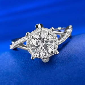 Macro shot of twisted band engagement ring with halo-set round brilliant diamond