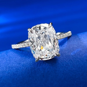 Macro view of cushion cut clear stone with four-prong setting on silver ring band