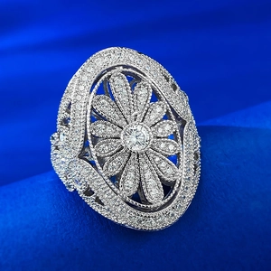 Luxurious silver flower ring with hollow design and zircon inlay on blue satin