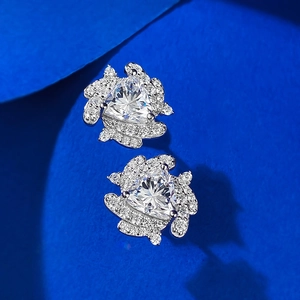 Macro shot of silver stud earrings featuring triangular stones and halo setting