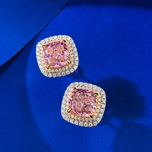 Boucles d'oreilles rose taille coussin avec double halo sur fond bleu profond