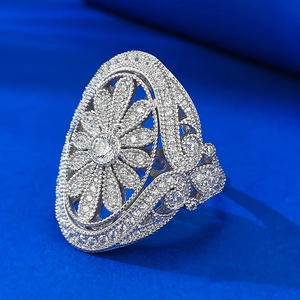 Vintage luxury hollow flower ring in silver with pavé white zircon stones on blue fabric