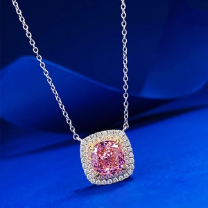 Pink cushion-cut gemstone necklace with double halo diamonds on deep blue silk background