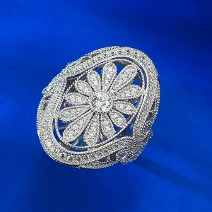 Macro shot of silver floral ring featuring intricate hollow baroque pattern and pavé crystals