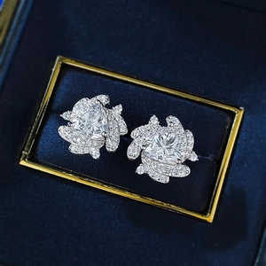 Macro detail of triangle cut earrings with halo setting in a blue velvet box
