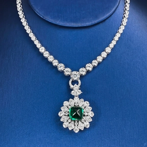 Détail d'un collier en argent avec émeraude carrée verte et halo de zircons blancs