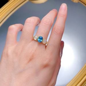 Detail of a 925 silver ring featuring blue Paraiba stone and white mother-of-pearl