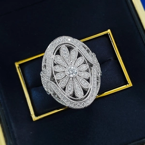 Macro shot of silver sunflower ring with intricate hollow petals and pavé diamonds