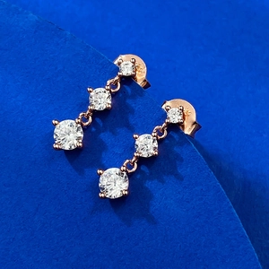 Nahaufnahme von S925 Roségold-Ohrringen mit drei funkelnden quadratischen Zirkonia-Steinen