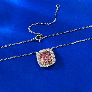 Pink cushion-cut stone pendant necklace with double diamond halo on a navy texture