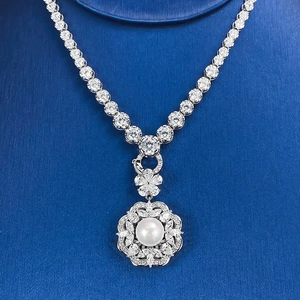 Vue macro d'un collier en argent avec pendentif perle blanche ronde et cristaux brillants