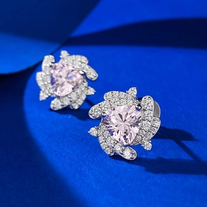 Pink heart-shaped zircon earrings with a spiral silver floral design on a blue background