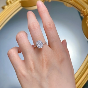 Close-up of cushion-cut square diamond ring with four-prong setting and side accents