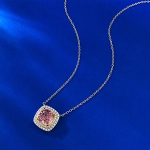 Macro view of square pink gemstone pendant with double halo diamond setting and silver chain