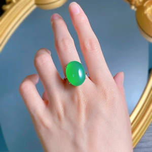 Detailed view of an oval green chalcedony silver ring worn on a finger