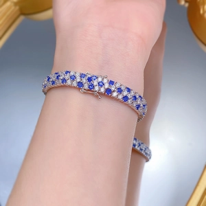 Gros plan d'un bracelet en argent S925 avec pierres bleu roi et blanches au poignet