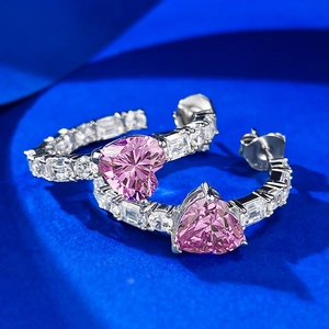 Vista macro di orecchini a cerchio in argento con zircone rosa a forma di cuore