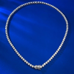 Detailed macro view of S925 silver tennis necklace with round cubic zirconia on blue silk