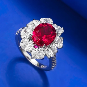 Détail d'une bague en argent S925 avec pierre rouge ovale et entourage de zircons