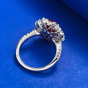 Détail d'une bague avec pierre rouge sang de pigeon ovale et monture halo scintillante en argent S925
