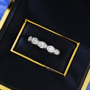 Macro detail of oval cut row diamond ring in navy velvet jewelry display box