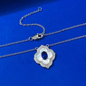 Macro detail of S925 silver necklace with royal blue gemstone and white shell petal pendant