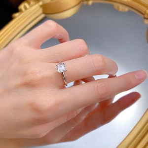 Macro view of a square-cut diamond ring on a hand with a vintage gold mirror background