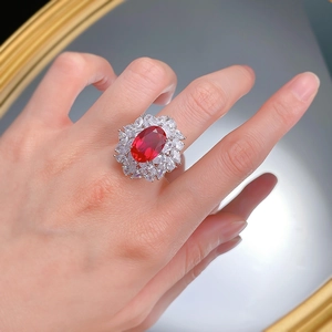 Macro detail of luxury oval red gemstone ring with double-row marquise diamond halo