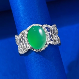 Macro shot of green chalcedony ring with halo diamonds and hollowed silver band