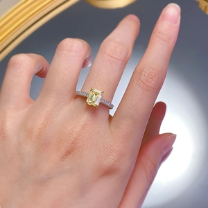 Luxurious 1.5 carat yellow emerald cut ring with pave diamond band on model's hand