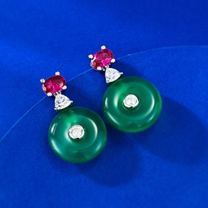 Macro detail of 925 silver gold-plated earrings with red gemstone and green chalcedony hoop
