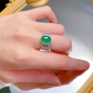 Detail of an oval green chalcedony ring with vintage lace hollow band and diamond halo