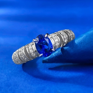 Macro shot of oval blue sapphire ring with spiral pavé diamond setting in 925 silver