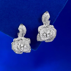 Elegant silver rose flower stud earrings with white zircons on dark blue velvet