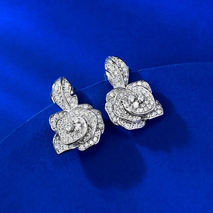 Macro shot of silver camellia stud earrings featuring shimmering pavé cubic zirconia