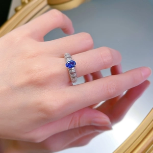 Macro detail of oval sapphire silver ring with ribbed band and pavé diamonds