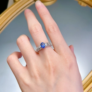 Close-up of S925 silver ring featuring an oval blue sapphire and textured band with diamonds