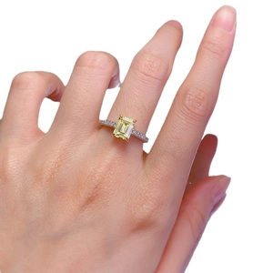 Elegant emerald-cut yellow gem ring with micro-paved diamonds on a silver-tone band