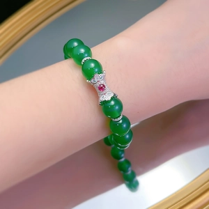Close-up of green jade agate beaded bracelet with a floral silver gemstone charm