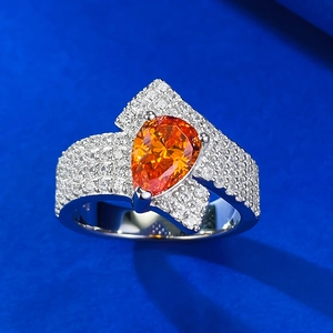 Macro shot of 925 silver ring featuring a 2-carat pear-shaped orange gemstone and micro-pave diamonds