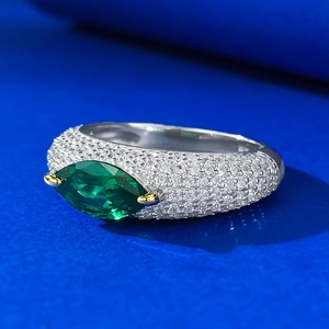 Detailed view of the green marquise gemstone and micro-paved diamonds on the gold prongs