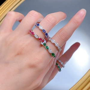 Detailed view of silver stackable rings with oval cut colorful gemstones on model hand