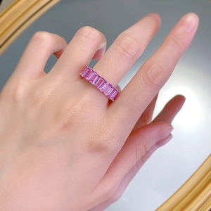 Detail of pink rectangular step-cut gemstones set in a silver band on a hand