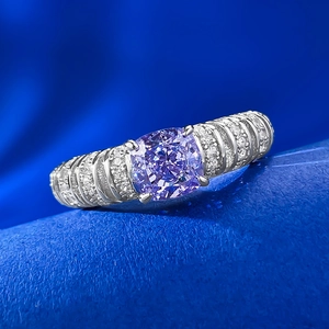 Macro shot of purple cushion cut diamond ring with pavé stones and silver band