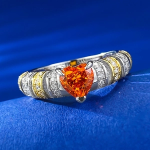 Macro shot of heart-shaped orange gemstone ring with two-tone band and pavé crystals
