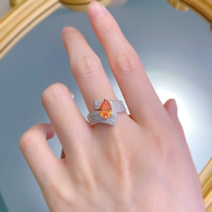 Detail of 925 silver ring featuring a 2ct pear-cut orange gemstone and pavé diamonds