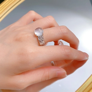 Close-up of a silver ring with translucent white jade stone and zircon micro-pave setting