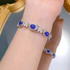 Gros plan détaillé d'un bracelet en argent 925 avec saphir bleu royal ovale et maillons fleuris